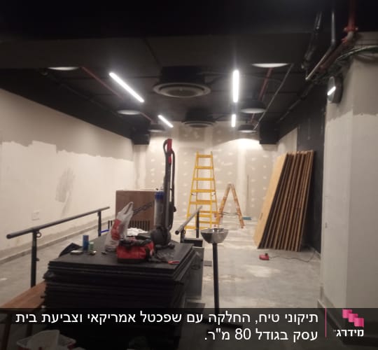 סולם צהוב, קירות צבועים למחצה, לוחות עץ על הרצפה